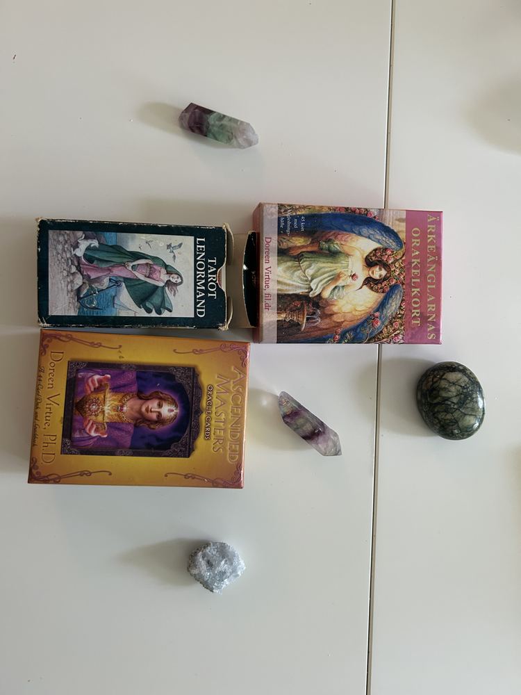 Tarot- och orakelkortlekar uppställda med kristaller omkring